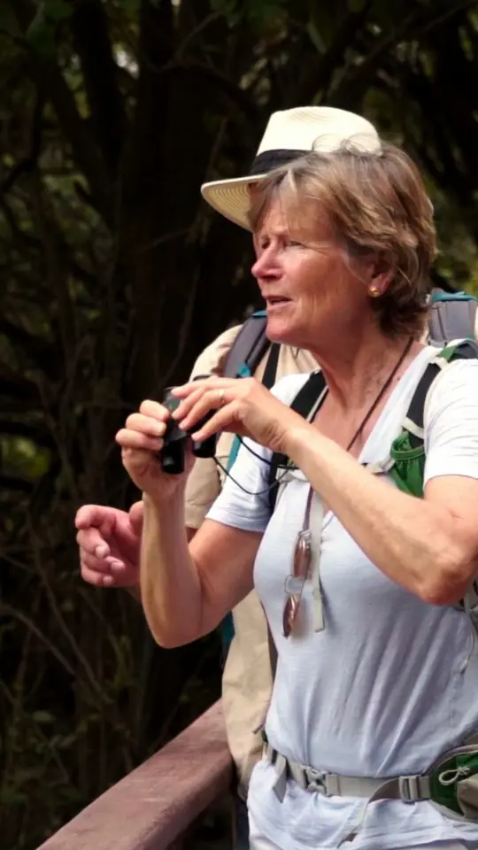 Reel cover: a traveller with binoculars on a coastal trail