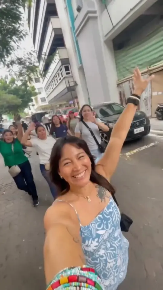 Reel cover: a smiling group waving on a Guayaquil street