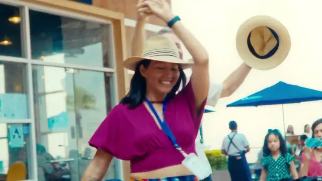 Video still: a woman in a straw hat dancing on a terrace