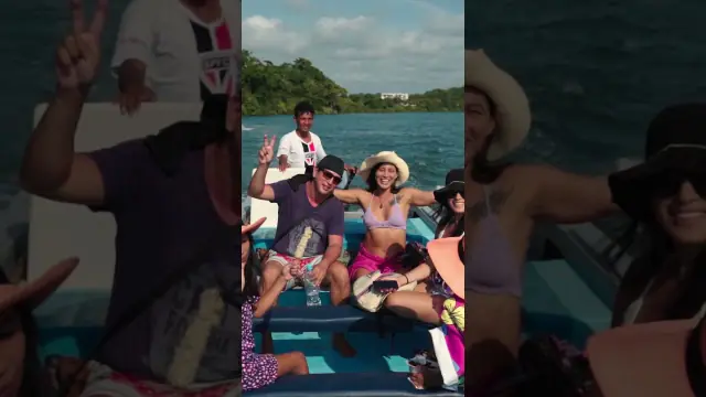 Video still: travellers waving from a boat at sea